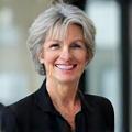 Portrait souriant d'Isabelle Dupont, directrice d'une agence de voyage parisienne moderne.